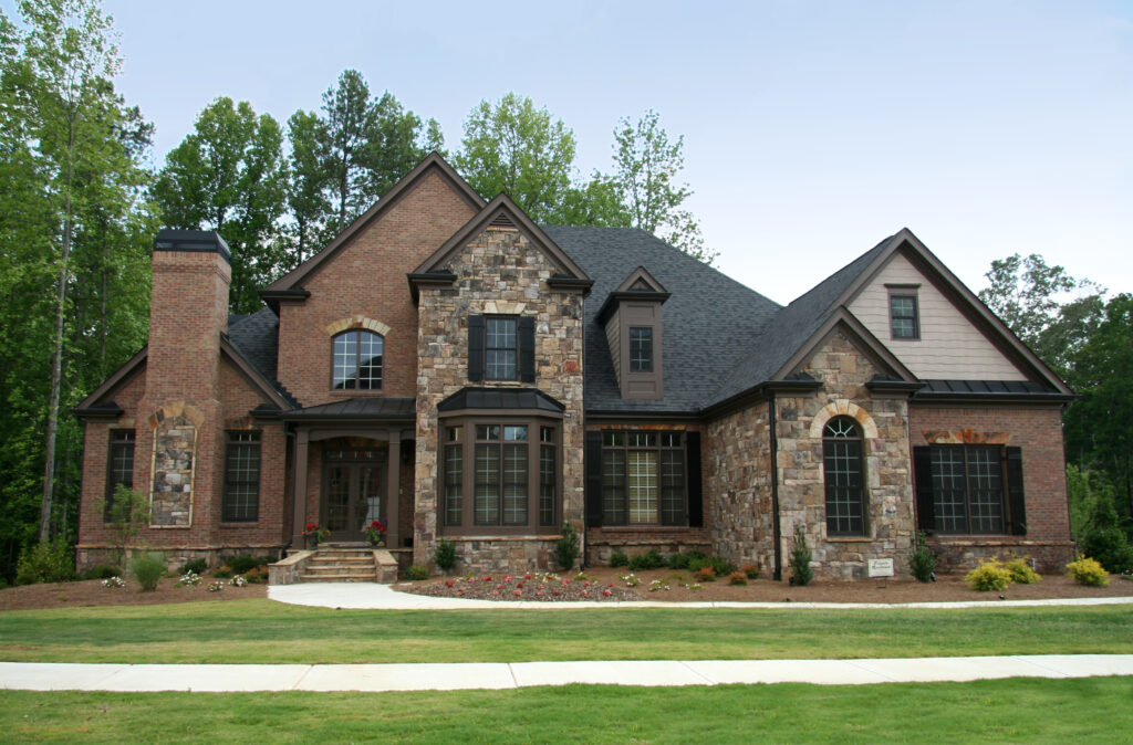 Large 2 story home with intricate stonework and brick